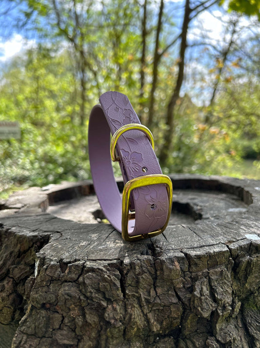 Floral printed dog collar in mauve on a log